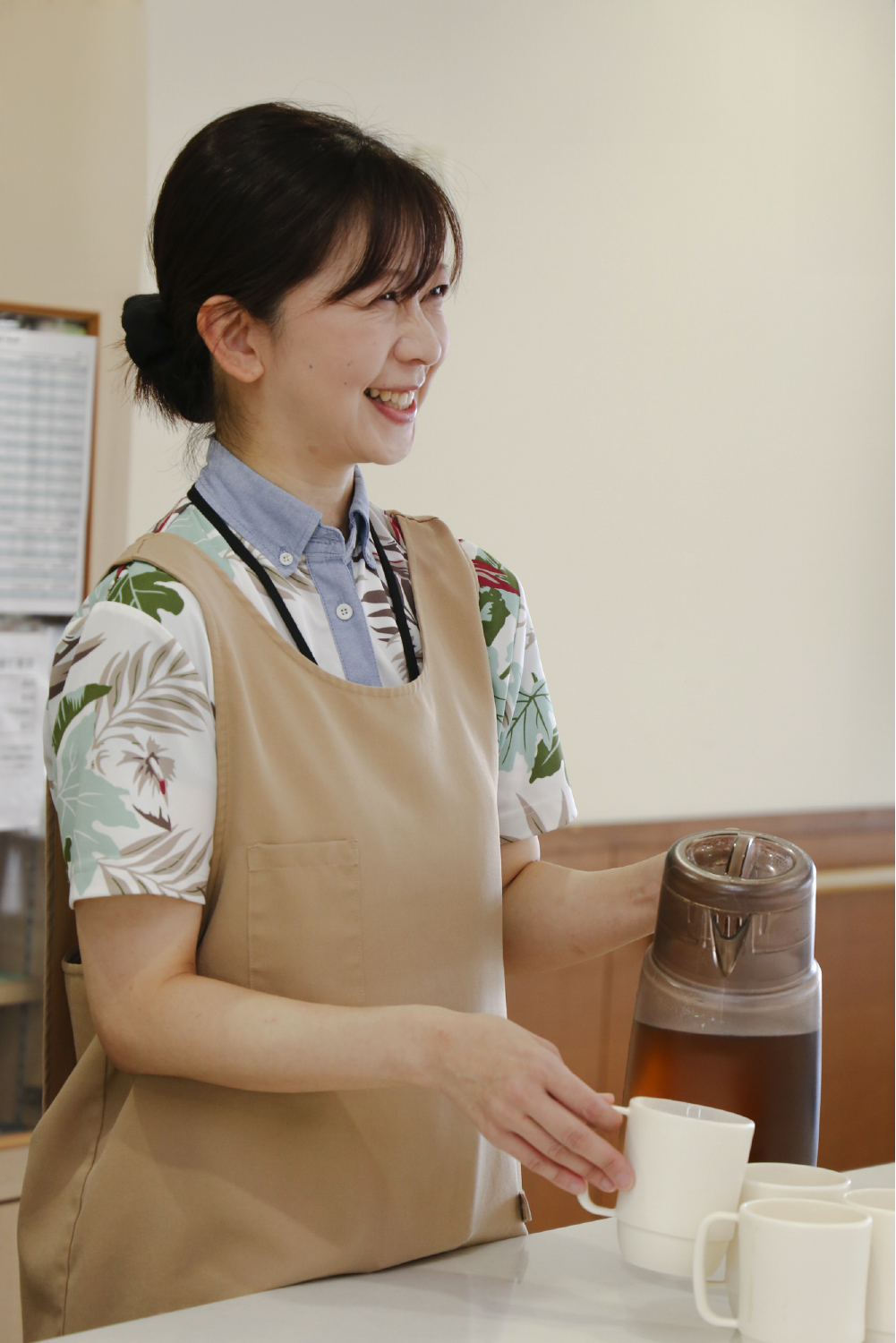 エプロンを着た笑顔の女性職員の写真